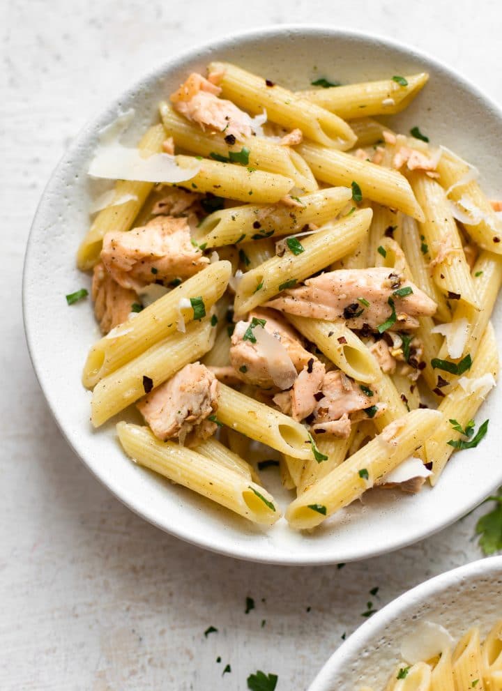 Garlic butter salmon pasta in a white bowl