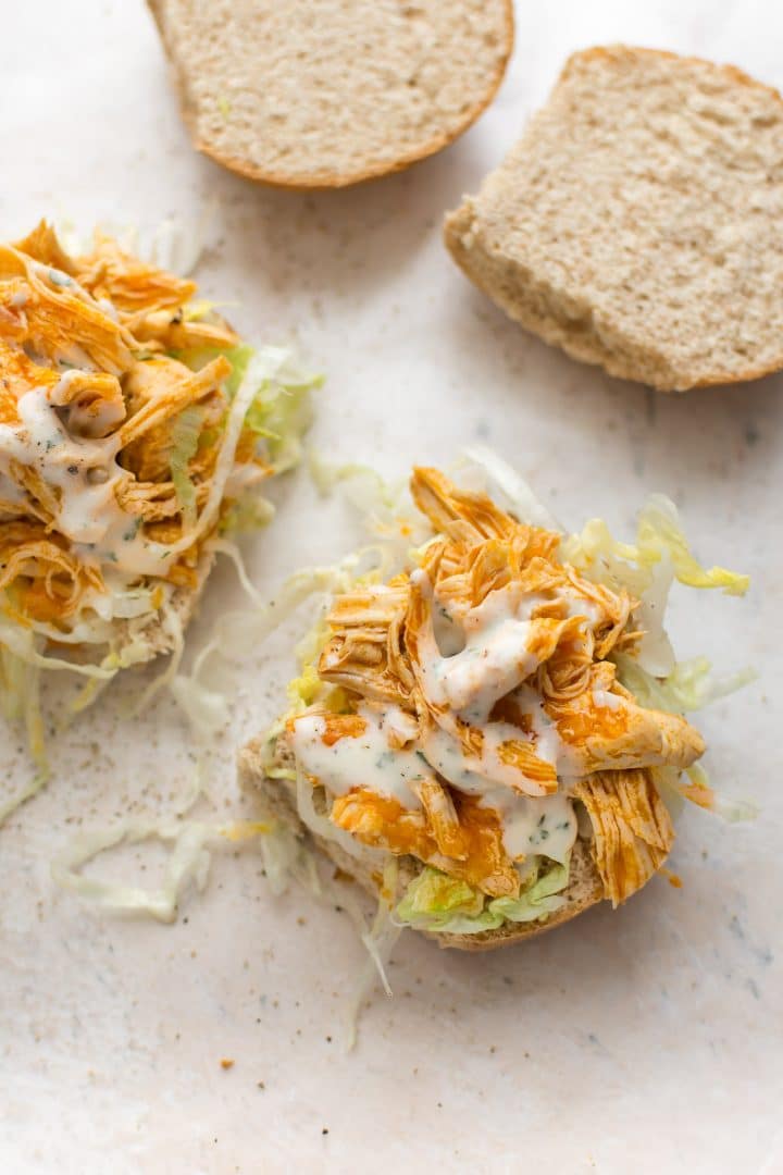 close-up of two easy instant pot buffalo chicken sandwiches with ranch dressing