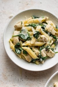 chicken spinach pasta in a white bowl