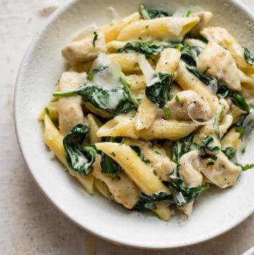 chicken spinach pasta in a white bowl
