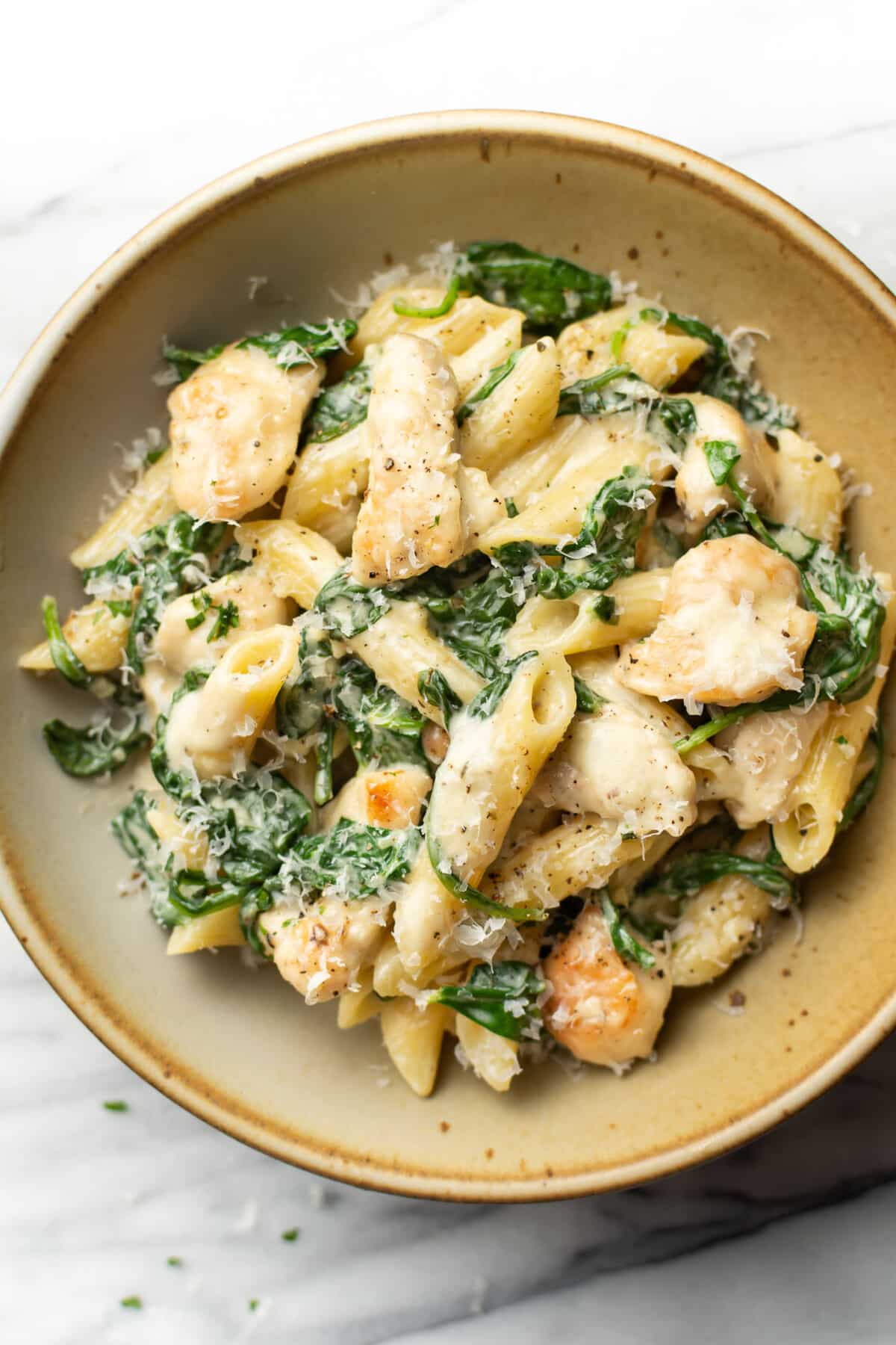 a bowl of creamy chicken spinach pasta