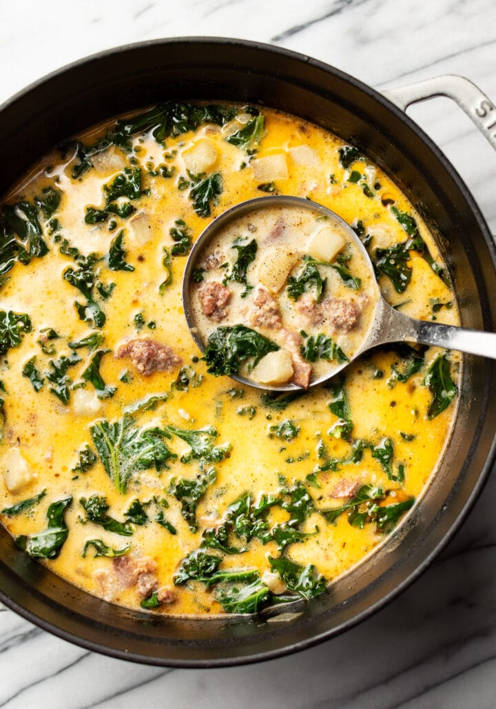 a pot and ladle of zuppa toscana