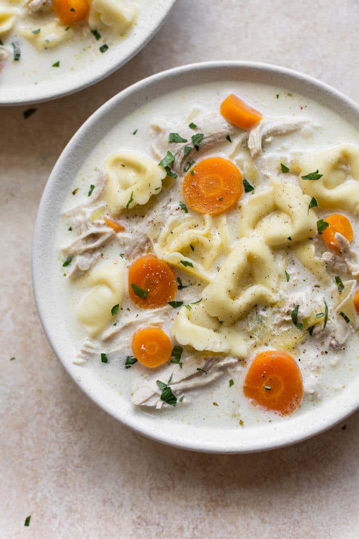 creamy chicken tortellini soup in a white bowl