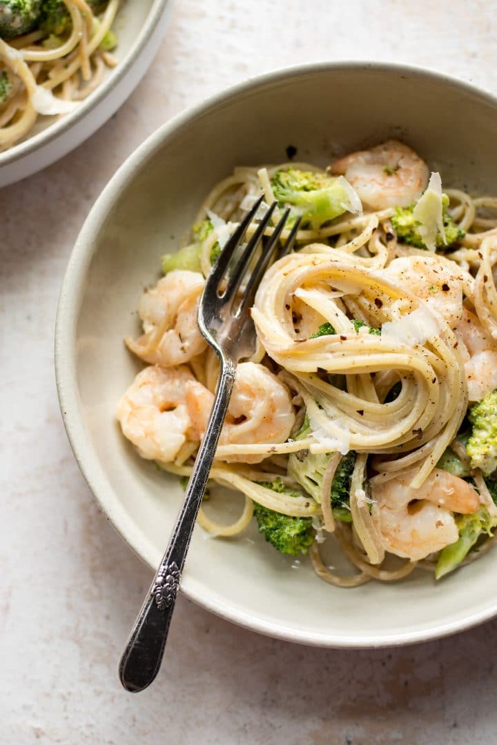 shrimp and broccoli pasta in a bowl with a fork