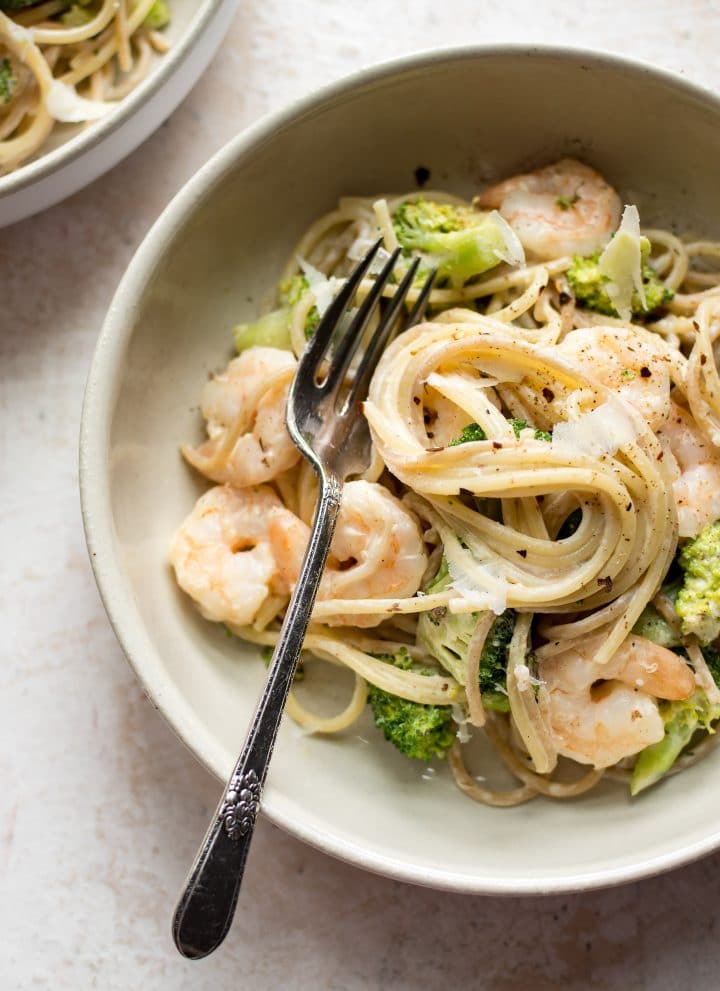 shrimp and broccoli pasta in a bowl with a fork