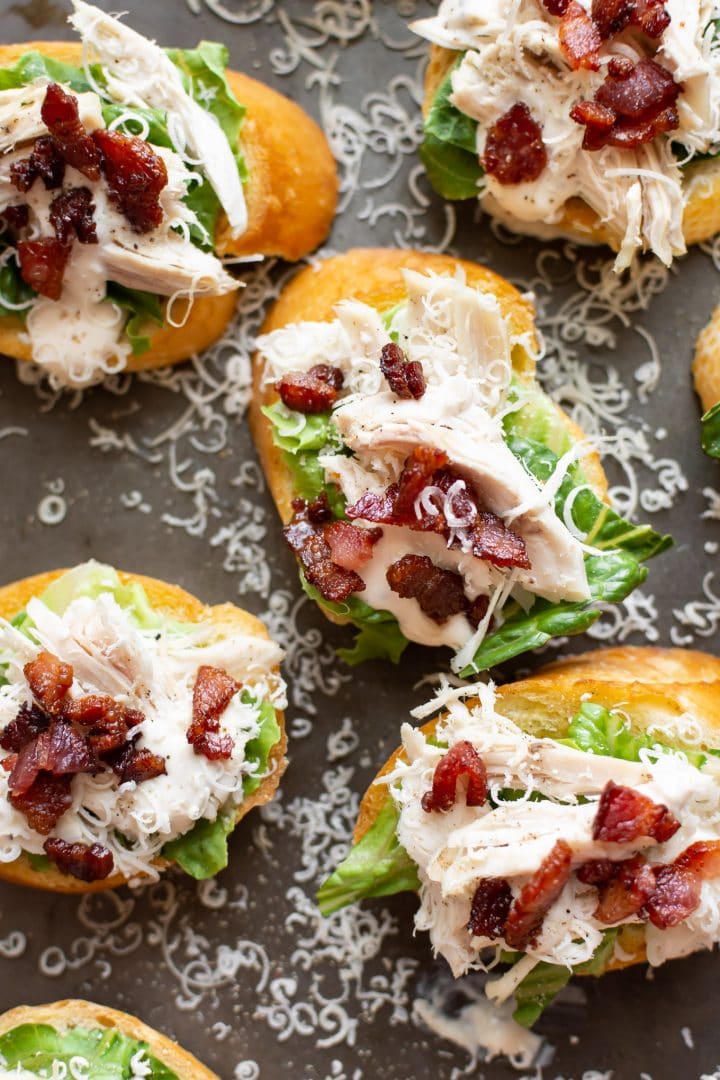 chicken caesar salad crostini on a baking sheet