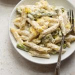 asparagus pasta with fork in two white bowls