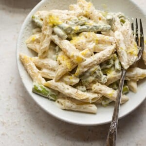 asparagus pasta with fork in two white bowls