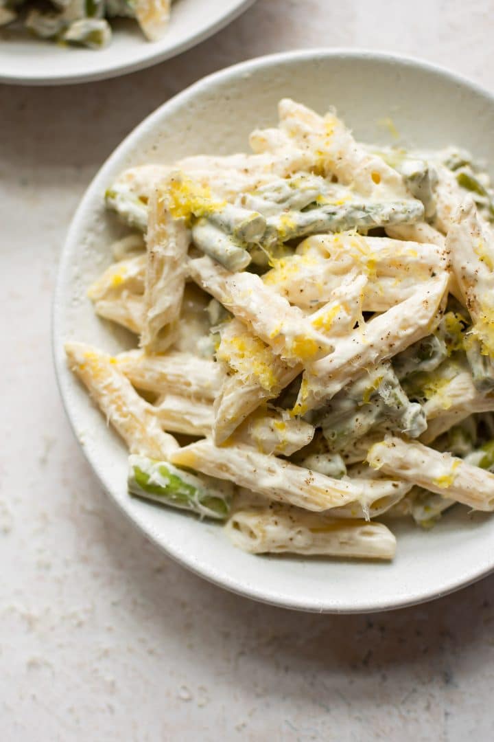 creamy asparagus pasta in white bowl