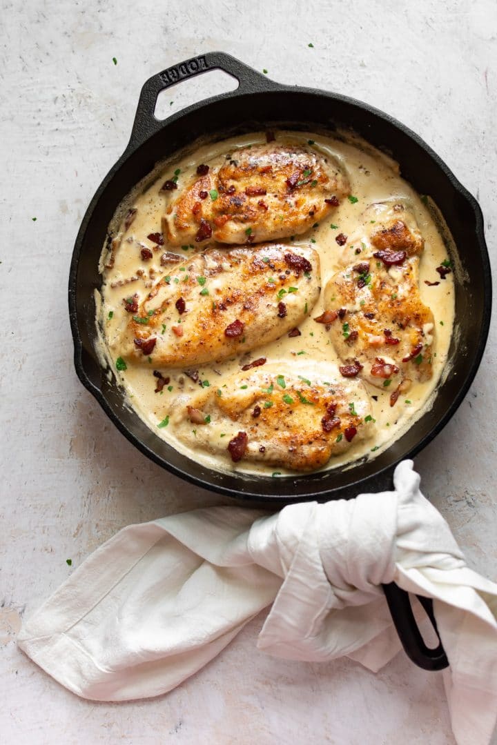 chicken with a creamy bacon sauce in a cast iron pan