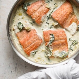 spinach and artichoke salmon in a skillet