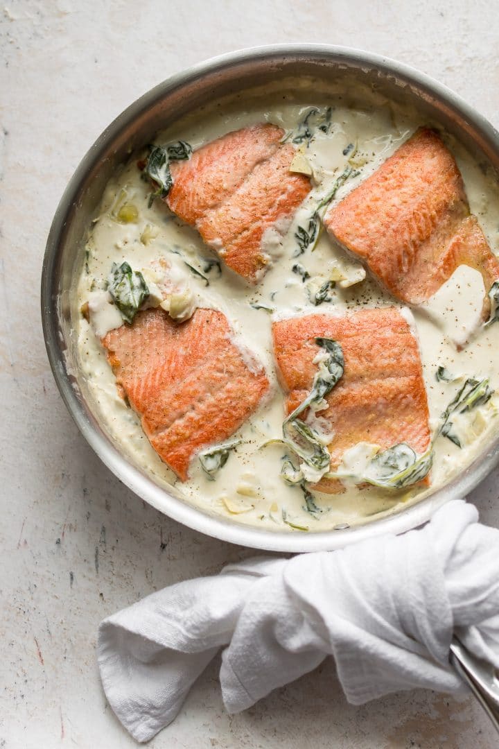 spinach and artichoke salmon in a skillet