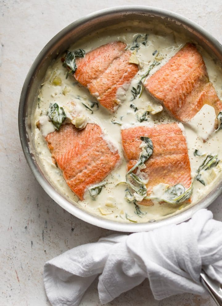 spinach and artichoke salmon in a skillet