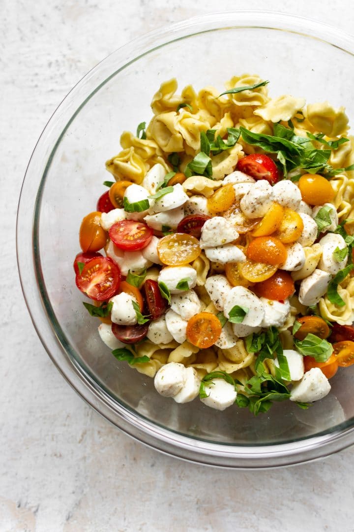 Caprese tortellini pasta salad in a glass prep bowl