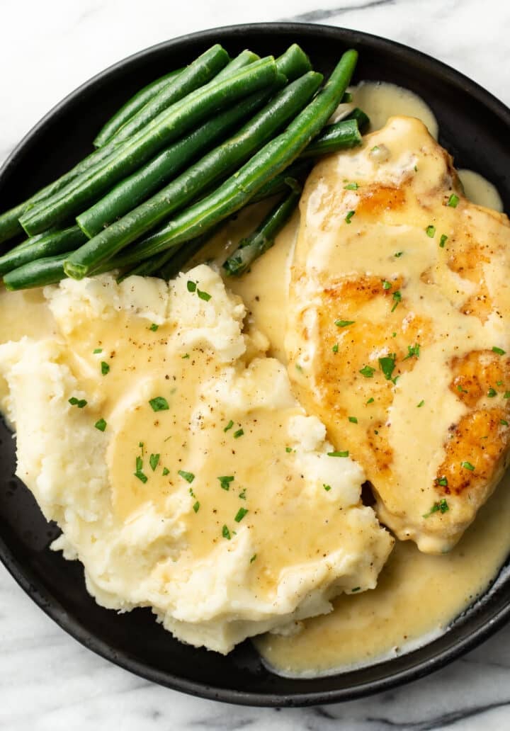 a plate with creamy honey mustard chicken, green beans, and mashed potatoes