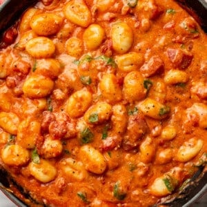 a skillet with gnocchi with tomato sauce