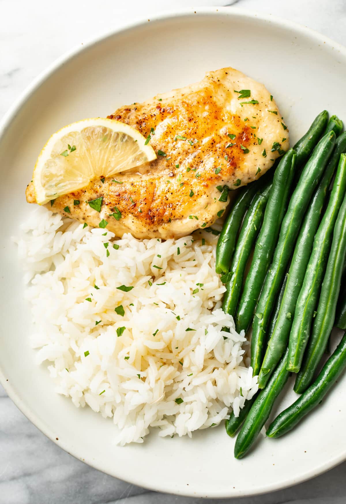 a plate with honey lemon chicken, rice, and green beans