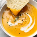 close-up of bread being dipped in a bowl of Instant Pot butternut squash soup