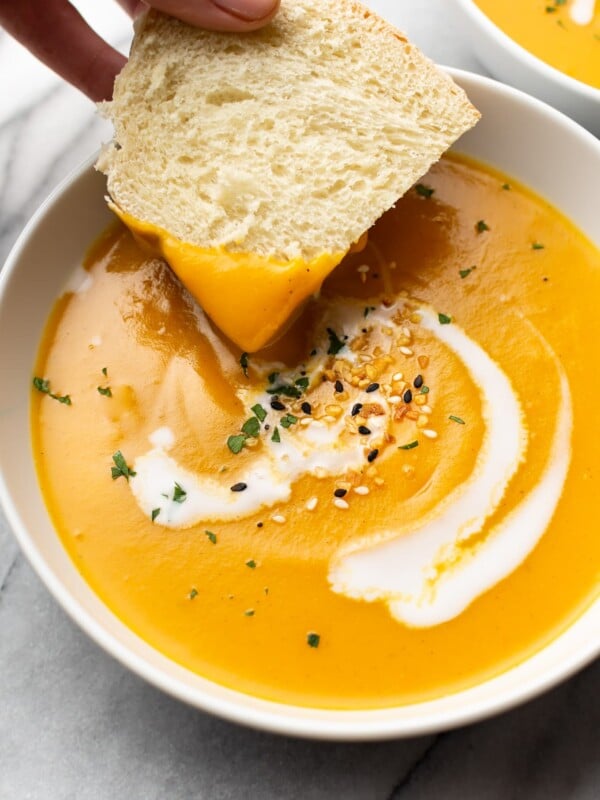 close-up of bread being dipped in a bowl of Instant Pot butternut squash soup