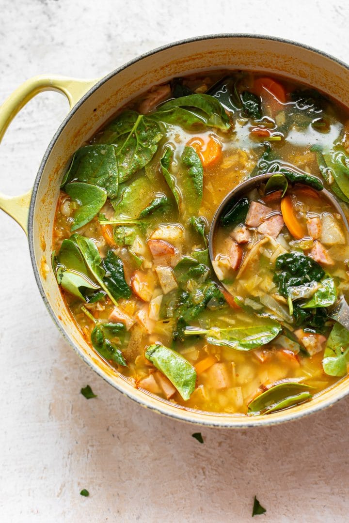 cabbage and kielbasa soup in a yellow cast iron pot