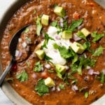 a bowl of black bean soup with a spoon