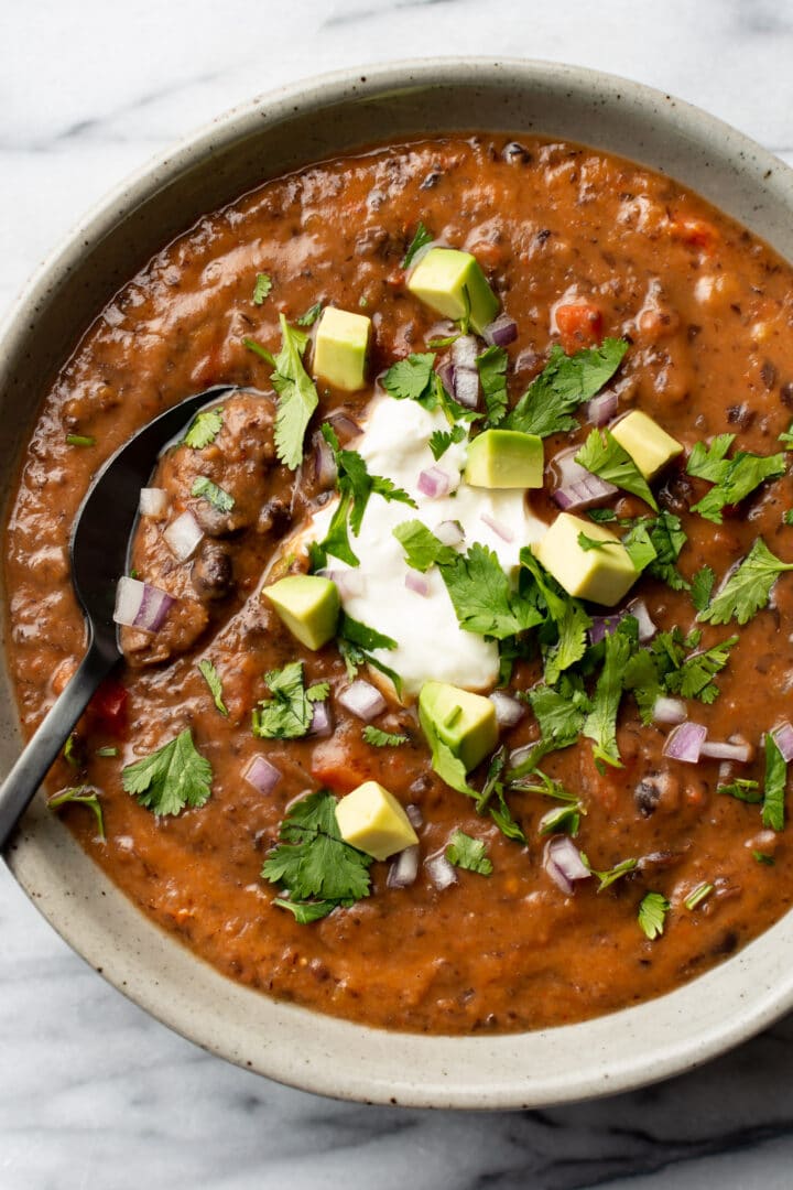 a bowl of black bean soup with a spoon