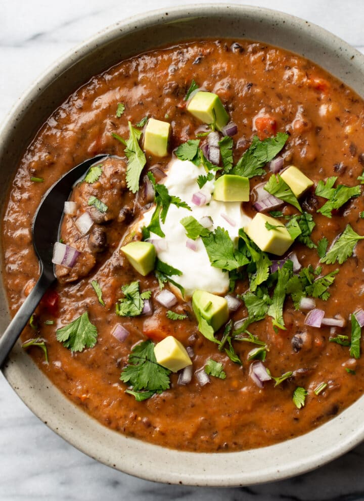 a bowl of black bean soup with a spoon