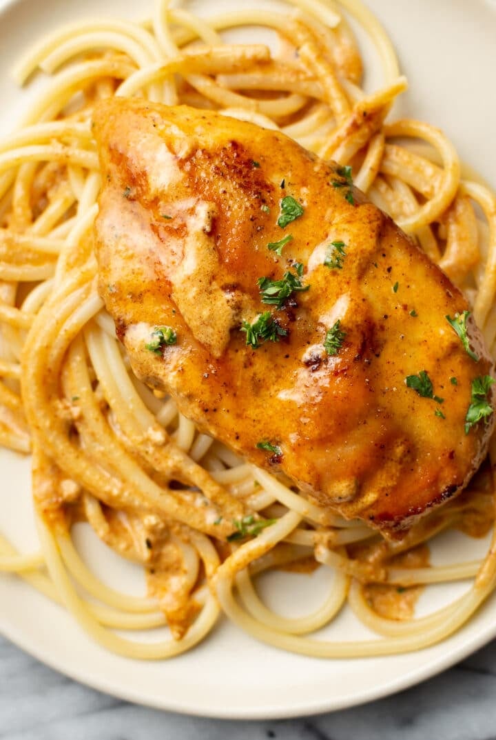 a plate with chicken lazone over pasta