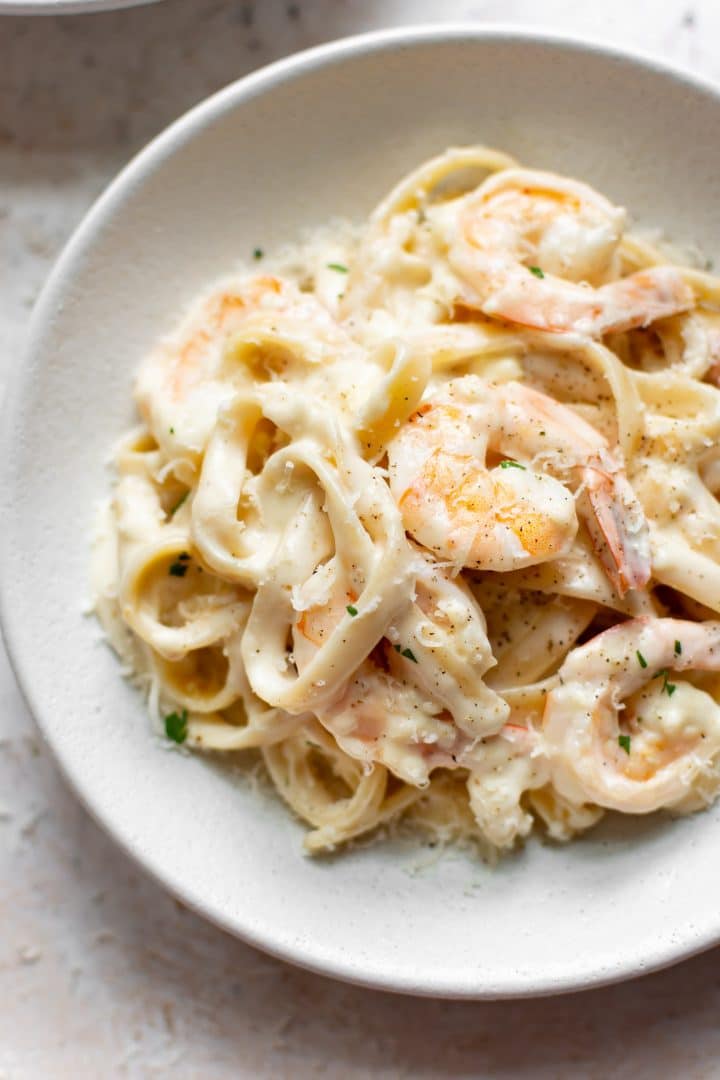 shrimp fettuccine alfredo in a white bowl (close-up)