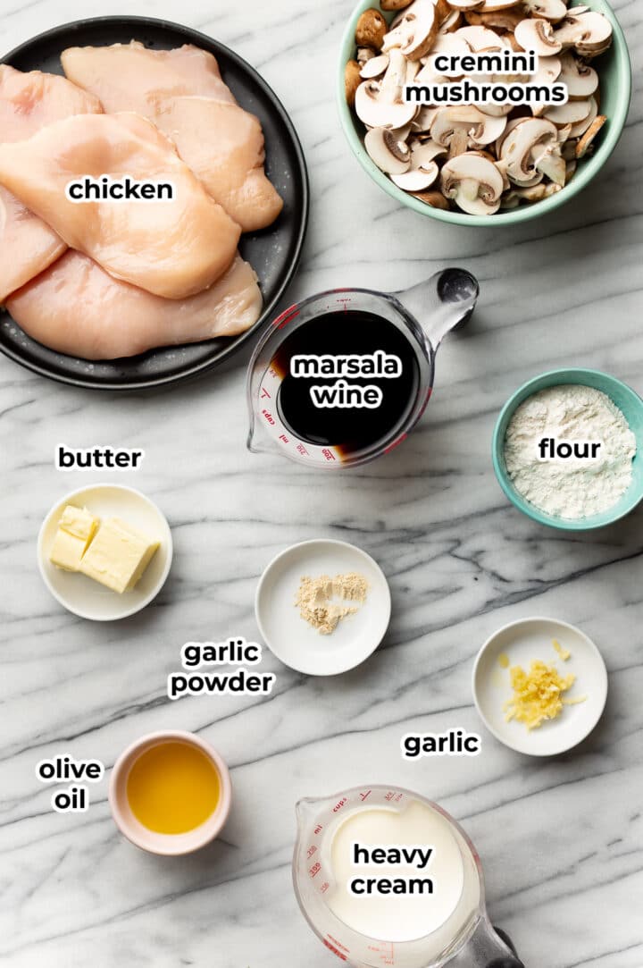 ingredients for chicken marsala on a marble counter