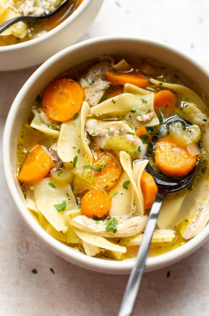 chicken noodle soup close-up in a bowl with a spoon