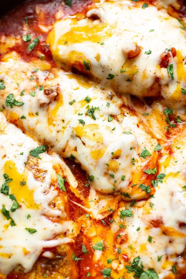extreme close-up of baked salsa chicken with melted cheese