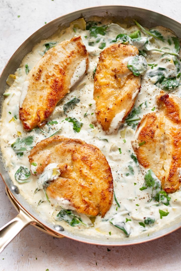 spinach artichoke dip chicken breasts in a skillet
