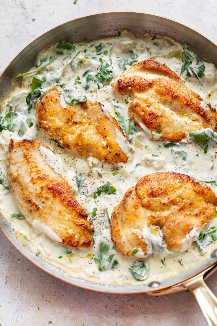 spinach and artichoke chicken in a skillet