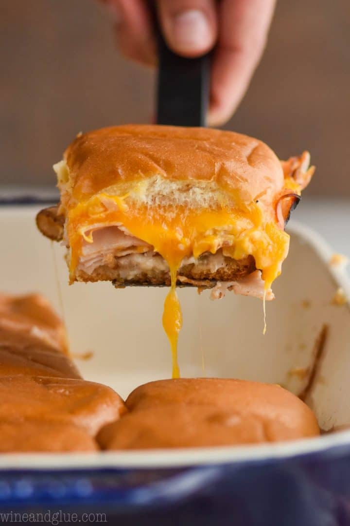 close-up of a turkey slider being lifted out of a baking dish