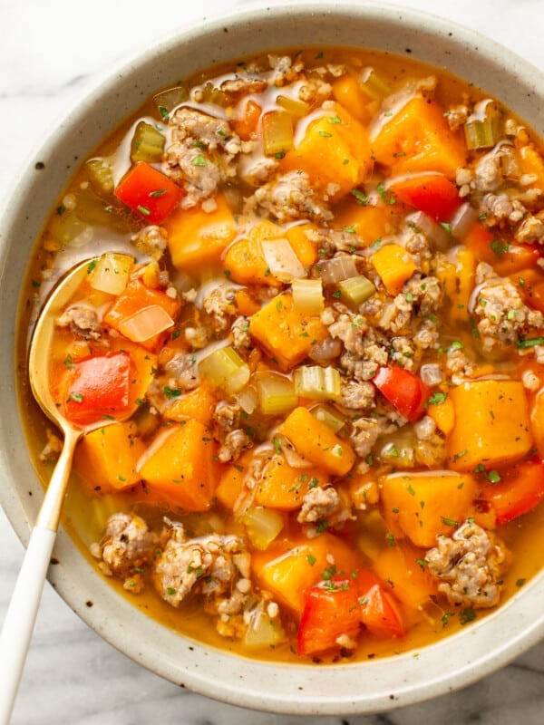 a bowl of italian sausage sweet potato soup with a spoon