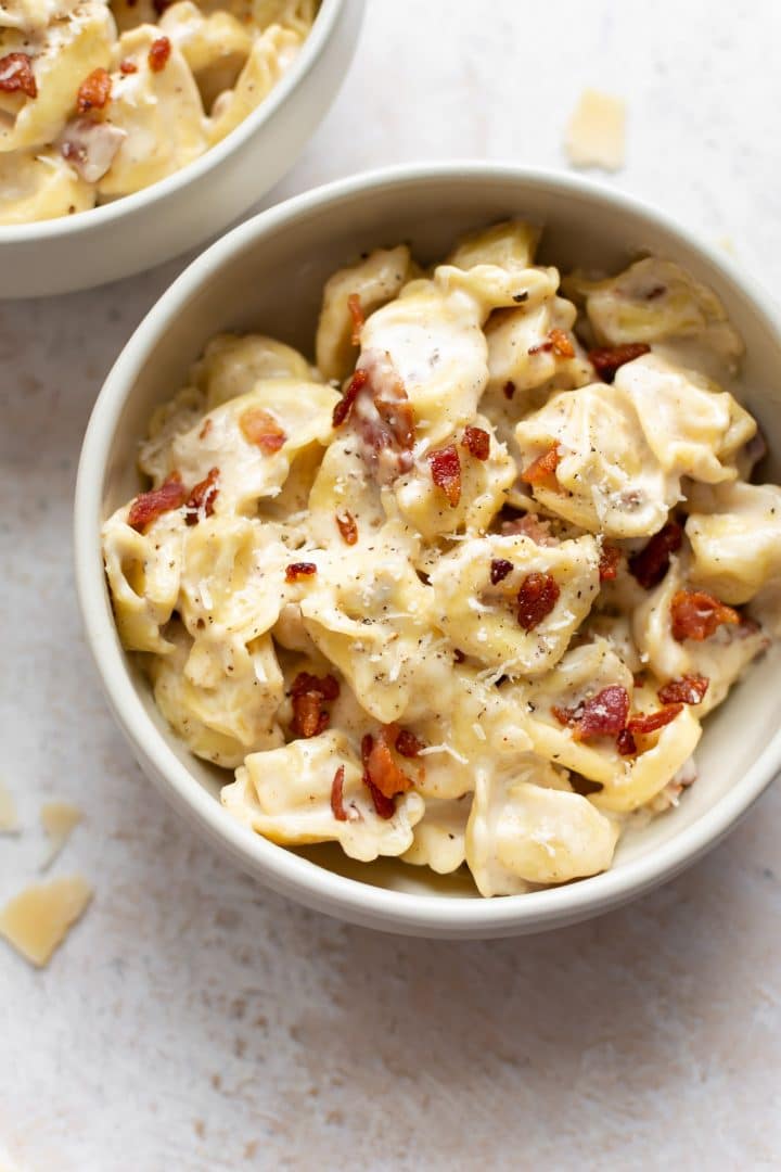 creamy tortellini with bacon in two bowls