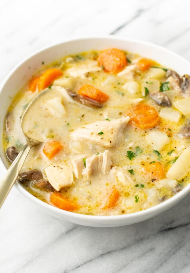 a bowl of chicken stew with a spoon