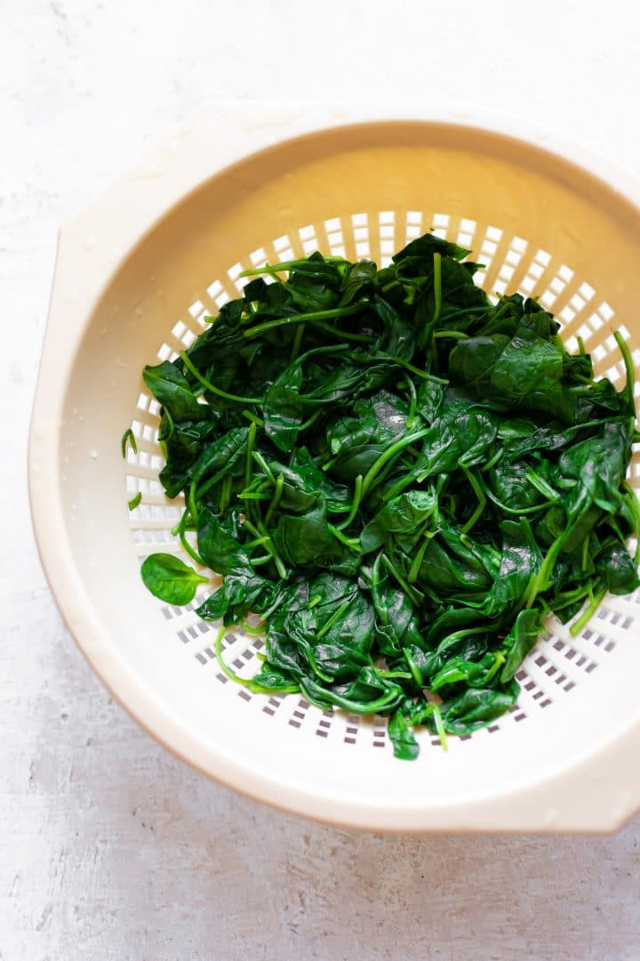 fresh blanched spinach in a colander