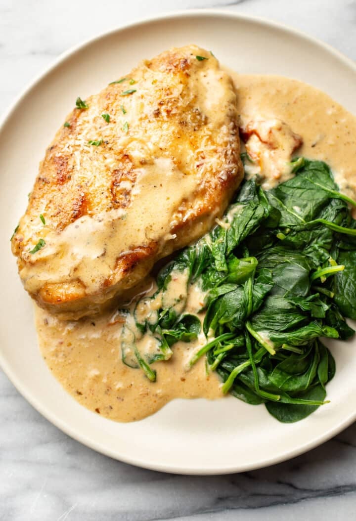 a plate with creamy cajun chicken and spinach