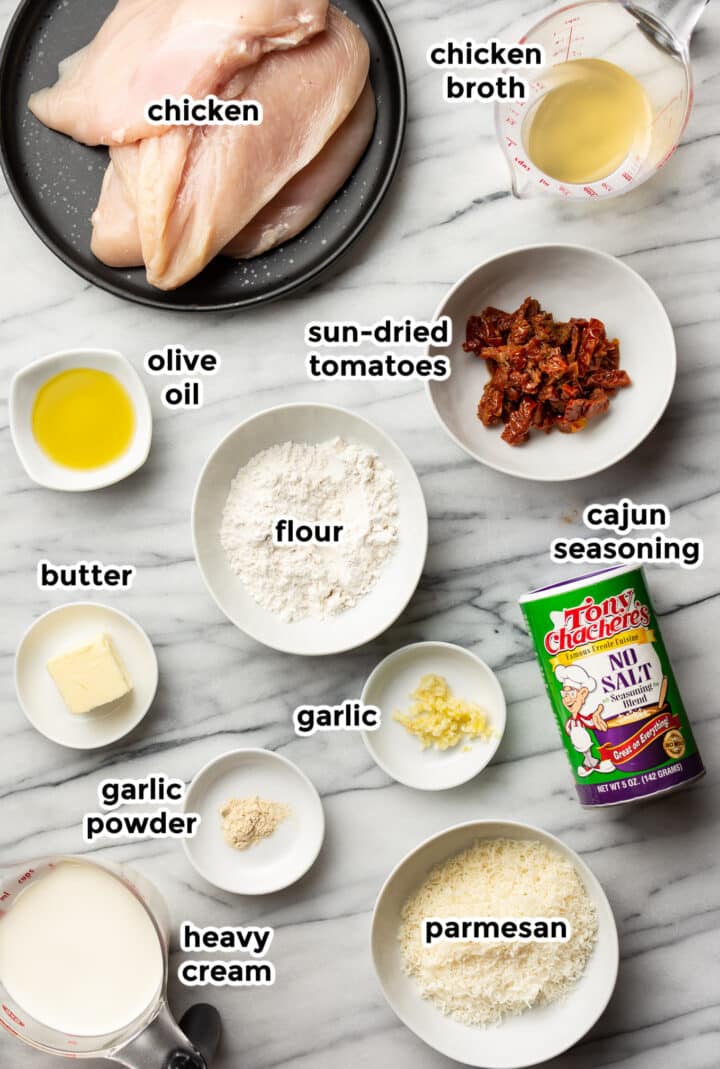 ingredients for creamy cajun chicken in prep bowls on a countertop