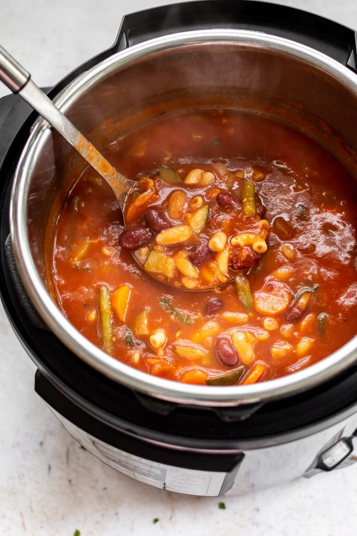 The best Instant Pot minestrone soup (pictured in the electric pressure cooker with a ladle)