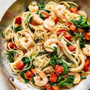 tomato spinach shrimp pasta in a skillet