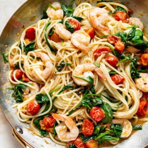 tomato spinach shrimp pasta in a skillet