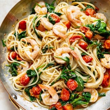 tomato spinach shrimp pasta in a skillet
