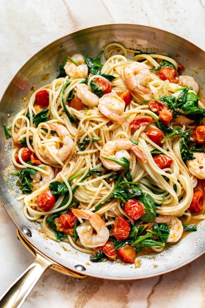 tomato spinach shrimp pasta in a skillet