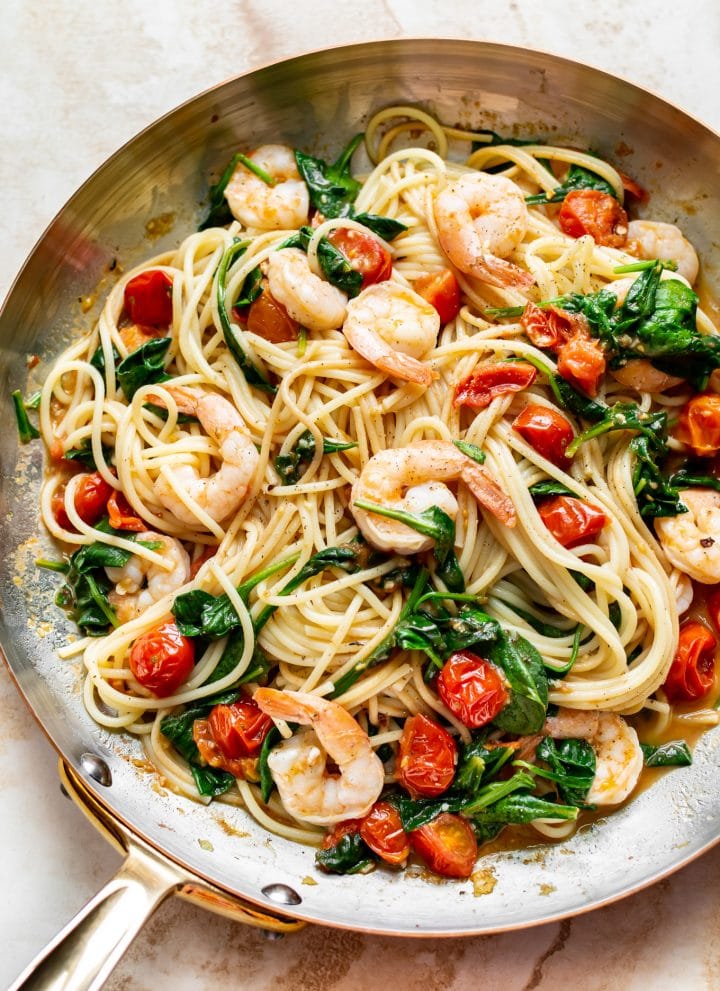 tomato spinach shrimp pasta in a skillet