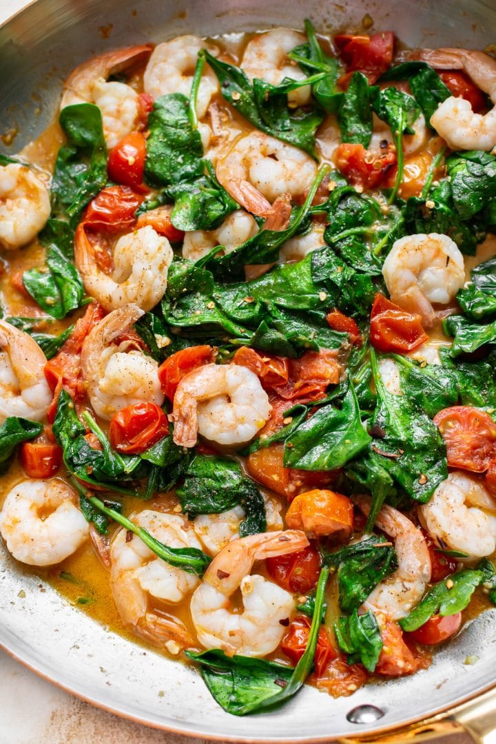 close-up of spinach tomato shrimp pasta sauce