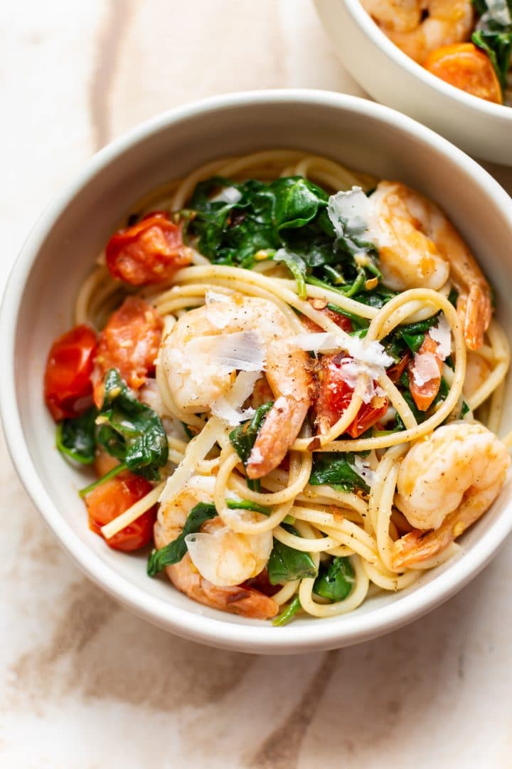 healthy shrimp spinach pasta in two white bowls