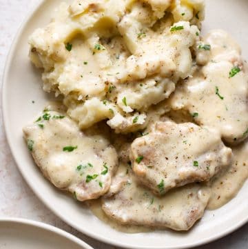 creamy pork tenderloin medallions close-up on a plate with mashed potatoes